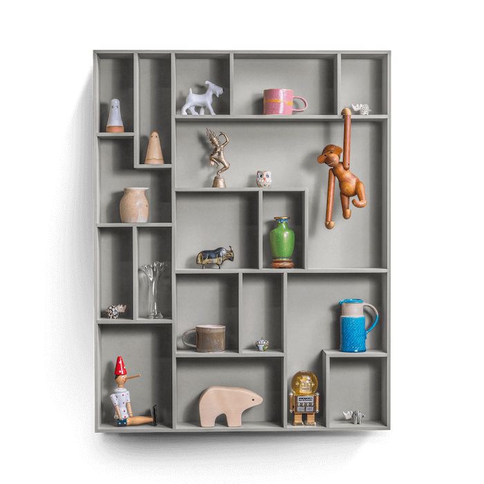 Decorative wall shelf with playful compartments and various displayed items.