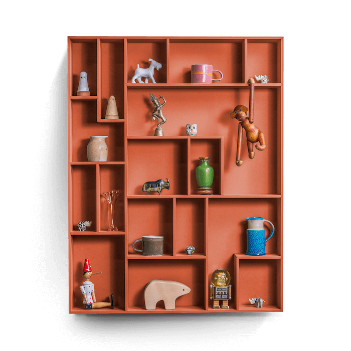 Sculptural decorative wall shelf with playful compartments displaying various keepsakes.