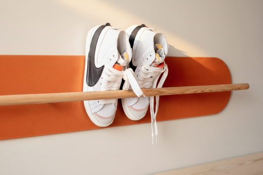 Orange Grounded wall-mounted shoe rack in solid oak holding white sneakers on a light wall, small home storage