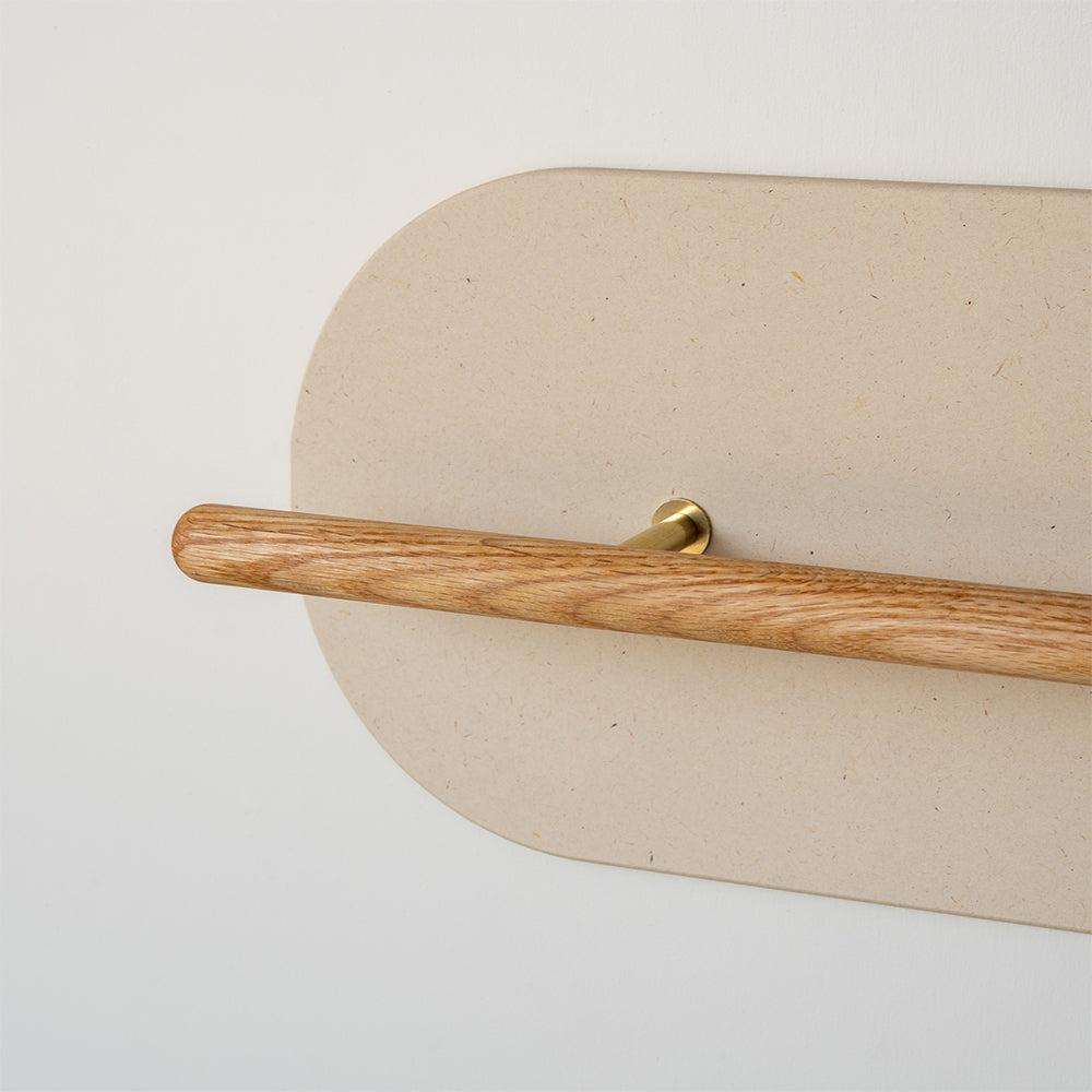 Grounded wall-mounted shoe rack with a solid oak rail, brass fittings and a Valchromat® Wall Protector