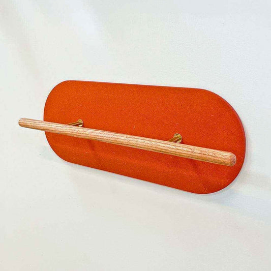 Sideview photo on a wooden Shoe Shelf with orange valchromat wall protector against a white wall.