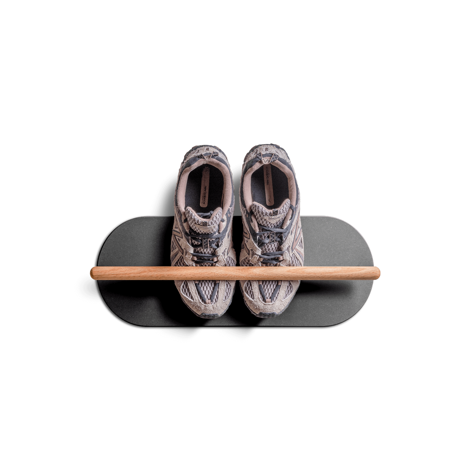Minimalist space saving shoe rack mounted on wall holding a pair of sneakers.