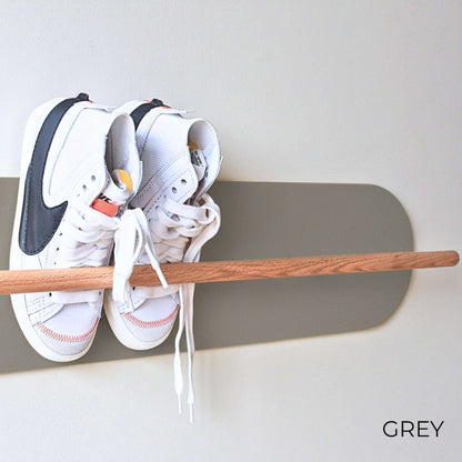 White Nike sneakers on a wooden Shoe  Shelf with Grey wall protector against a white wall.
