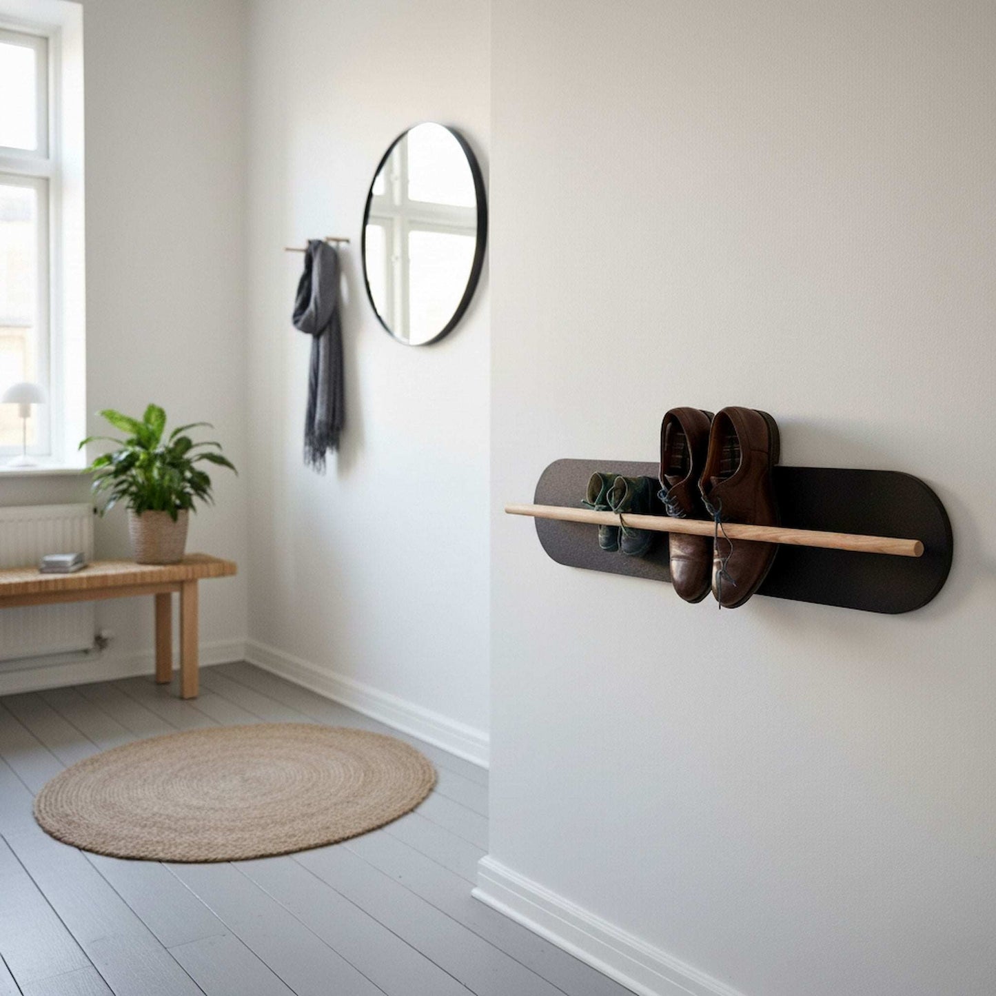 Shoe rack mounted on a white wall with shoes on it, next to a mirror and a plant.