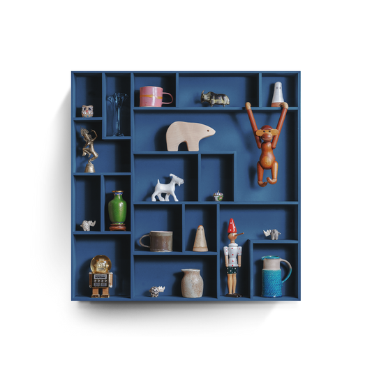 Decorative wall shelf with playful grid compartments displaying various keepsakes and objects.