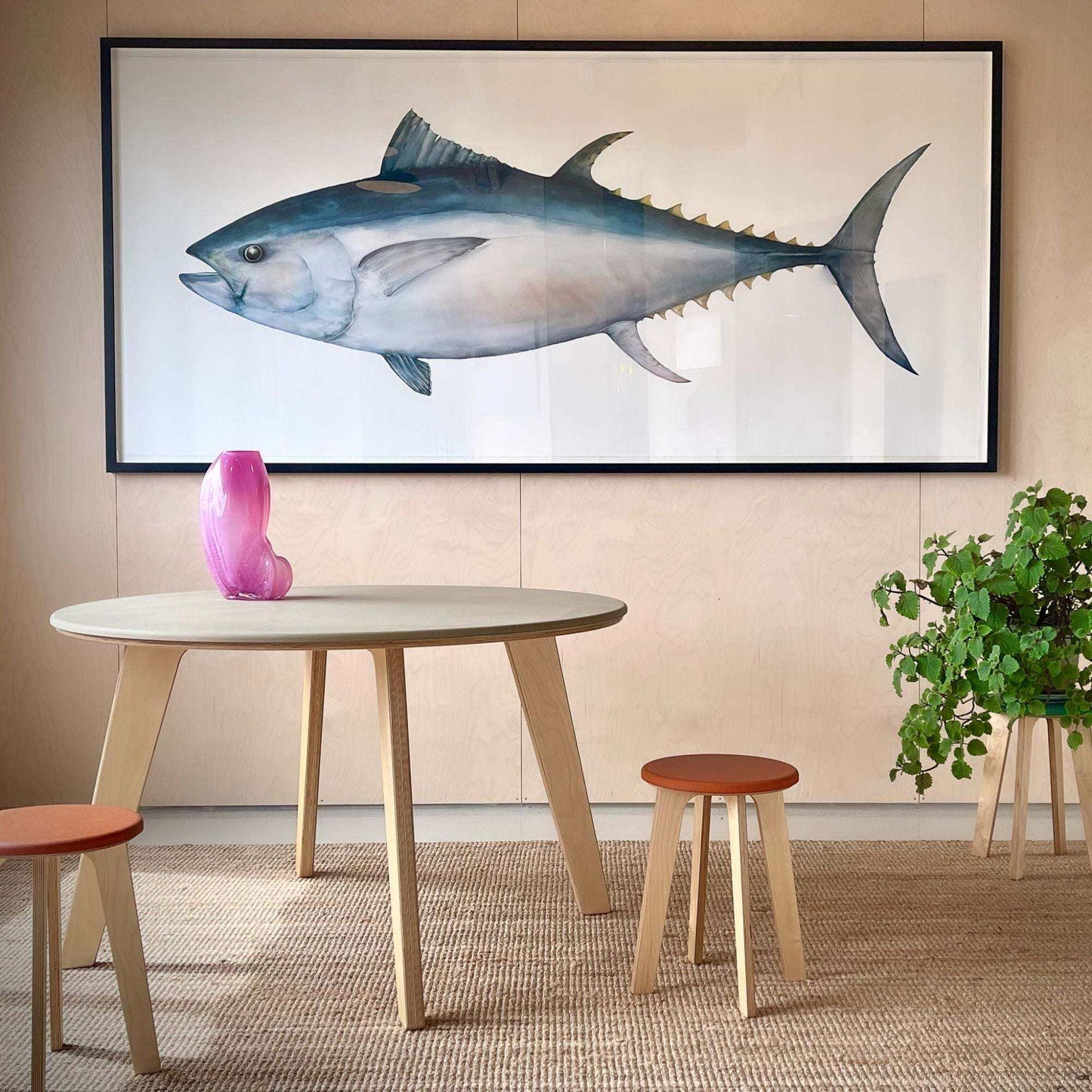 Minimalist birch dining table with round top and natural wood finish in modern room setting