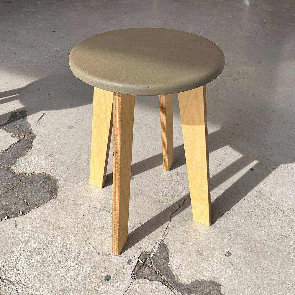 Bjørk Large wooden stool with blue Valchromat seat and natural wood legs on concrete floor