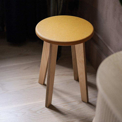 Elegant birch stool combining natural materials with playful color in minimalist design.