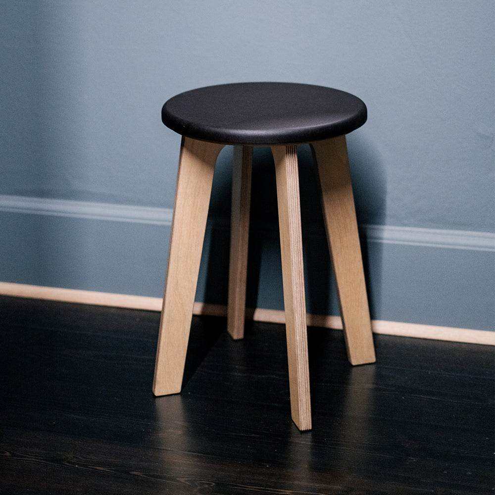 Elegant birch stool "Bjørk" with black seat in modern interior setting.
