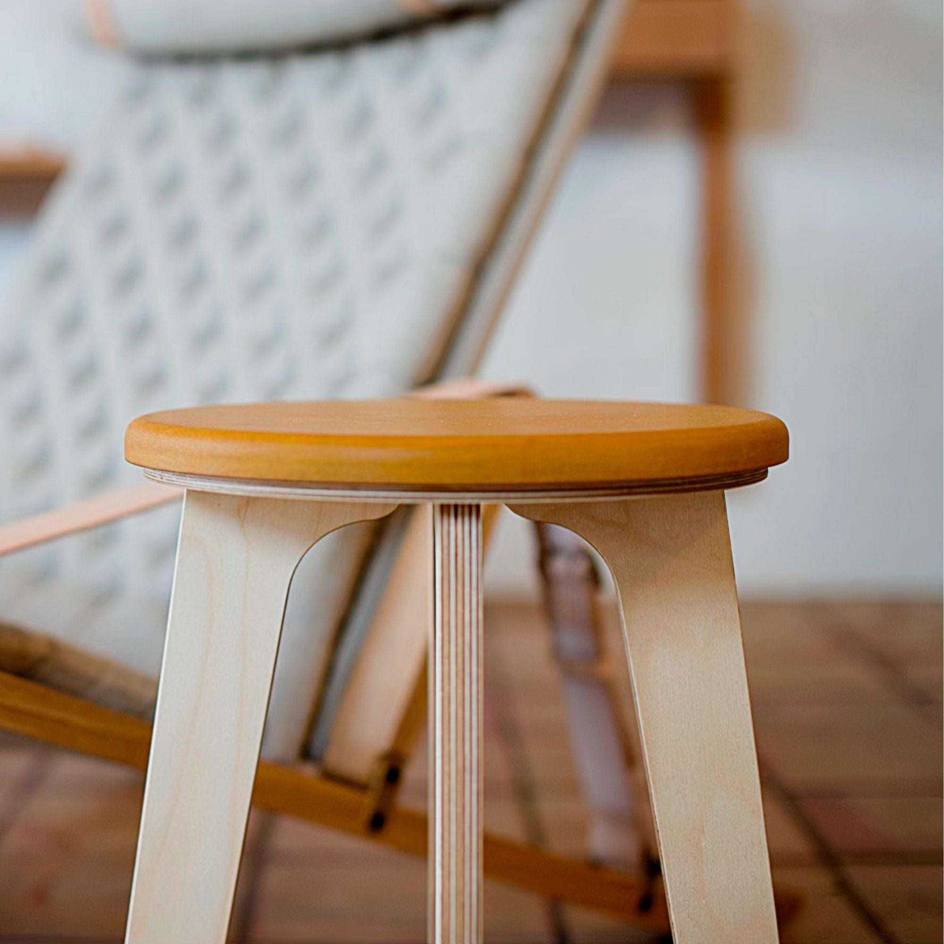 Minimalist birch stool with natural plywood legs and vibrant round seat for modern interiors