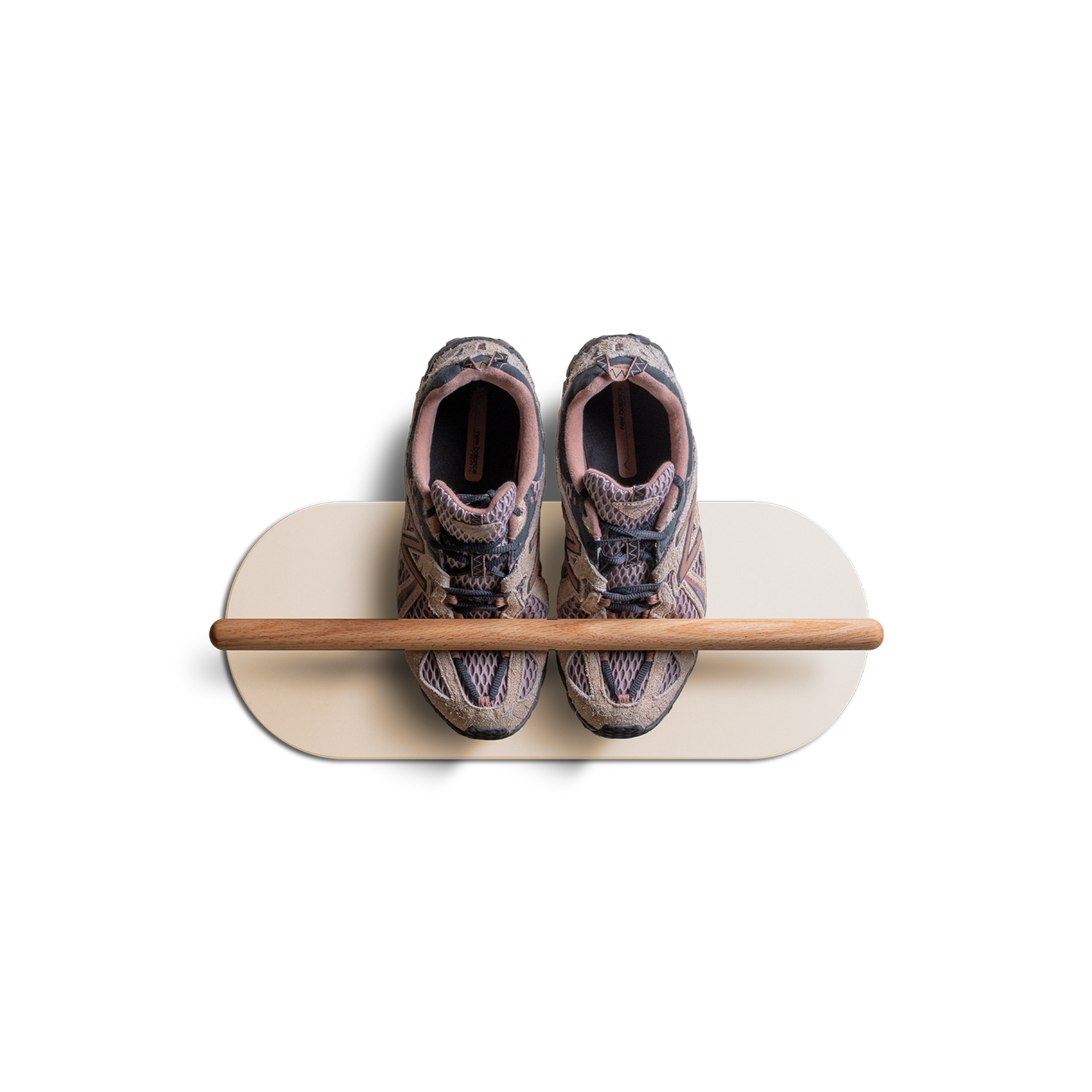Scarpiera sospesa a muro Grounded in bianco perla, con asta in rovere massello e protezione da parete in Valchromat®, con un paio di sneaker