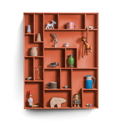 Sculptural decorative wall shelf with playful compartments displaying various keepsakes.
