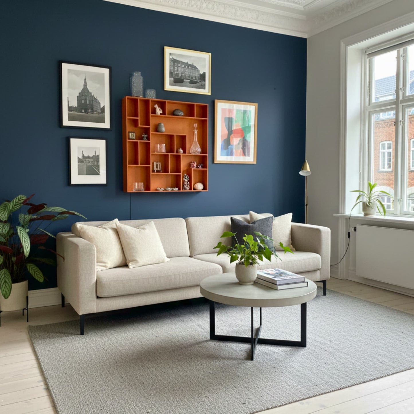 Modern Copenhagen living room with a beige sofa, coffee table, decorative wall art and an orange NicNac Box-Shelf