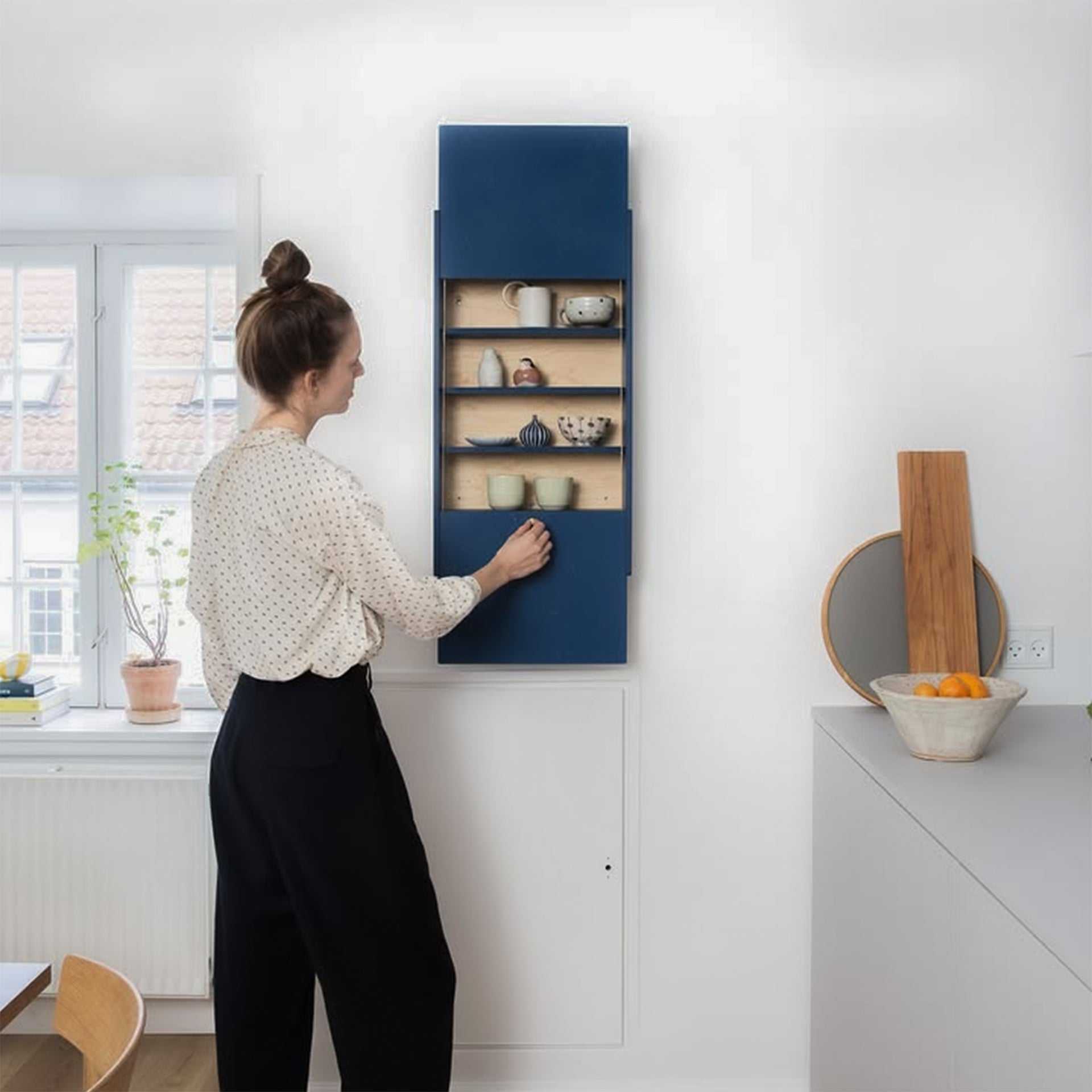 Space-saving cabinet with upward-gliding doors in a minimalist room setting.