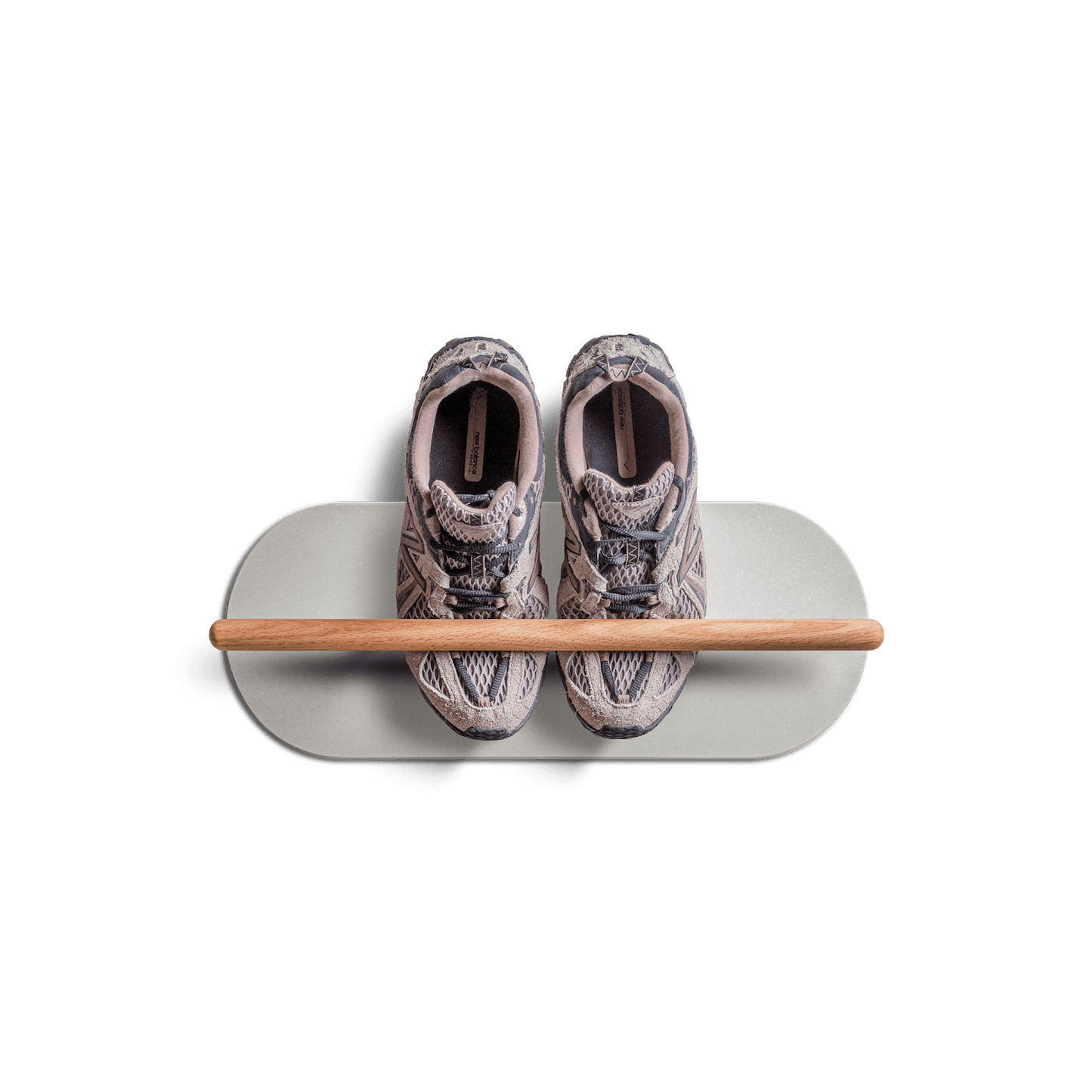 Minimalist space saving shoe rack with two sneakers on a floating shelf.