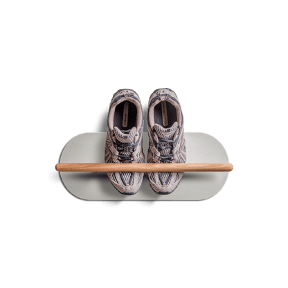 Minimalist space saving shoe rack with two sneakers on a floating shelf.