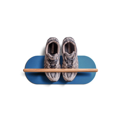 Minimalist space saving shoe rack in blue with wooden bar holding a pair of sneakers